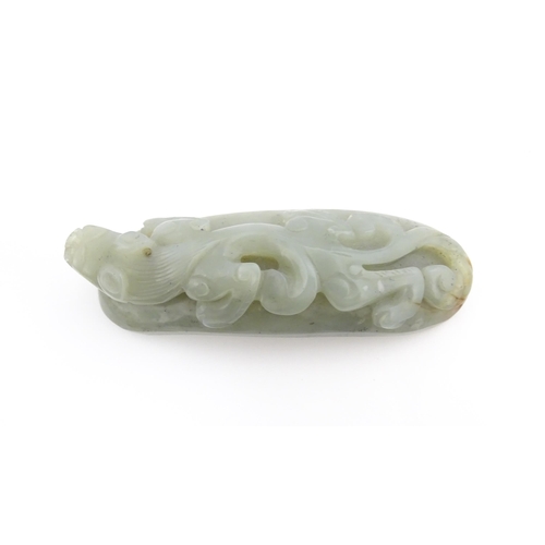 1022 - A Chinese carved jade coloured hardstone belt hook depicting a stylised chilong dragon. Approx. 3 1/... 