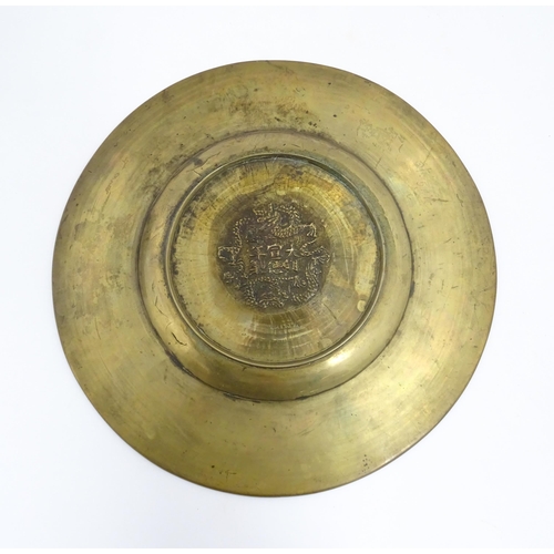 1042 - A Chinese brass charger with dragon and pearl of wisdom decoration and stylised bamboo border. Chara... 