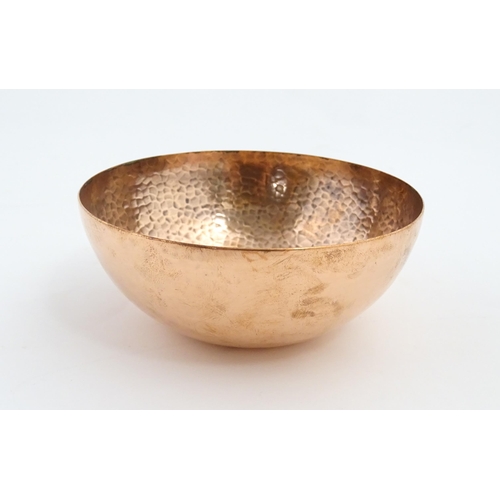 1046 - An Arts and Crafts small copper bowl with hammered decoration to interior. Stamped ' Newlyn ' under.... 