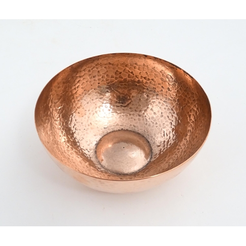 1046 - An Arts and Crafts small copper bowl with hammered decoration to interior. Stamped ' Newlyn ' under.... 