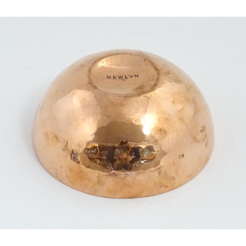 1046 - An Arts and Crafts small copper bowl with hammered decoration to interior. Stamped ' Newlyn ' under.... 