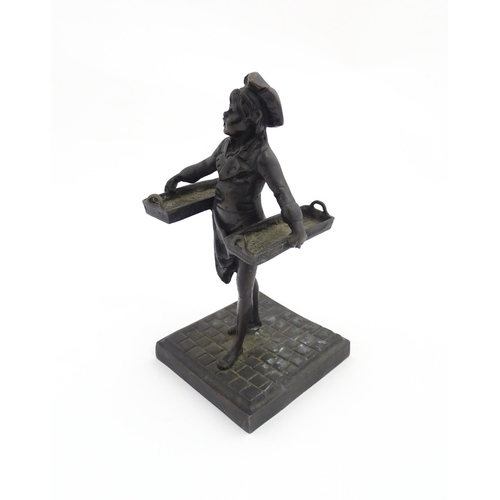 1047 - A 20thC cast figure depicting a Baker's Boy holding two baskets of elongated form. Approx. 9