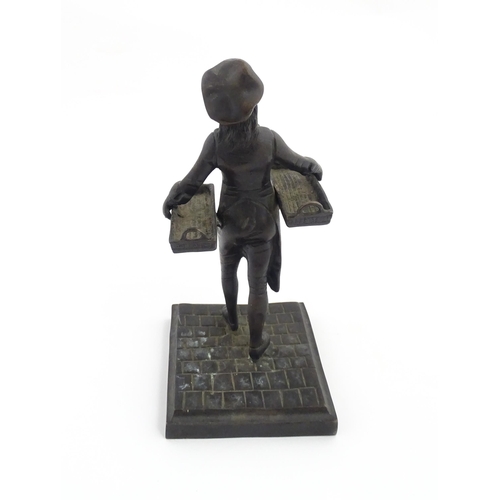 1047 - A 20thC cast figure depicting a Baker's Boy holding two baskets of elongated form. Approx. 9