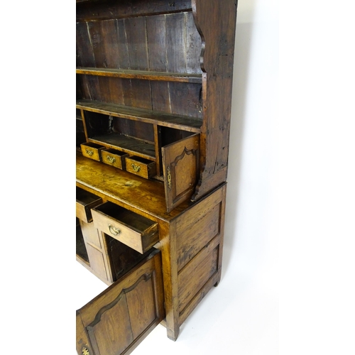 1591 - A mid 18thC oak dresser with a moulded cornice above three graduated shelves flanked by panelled cup... 