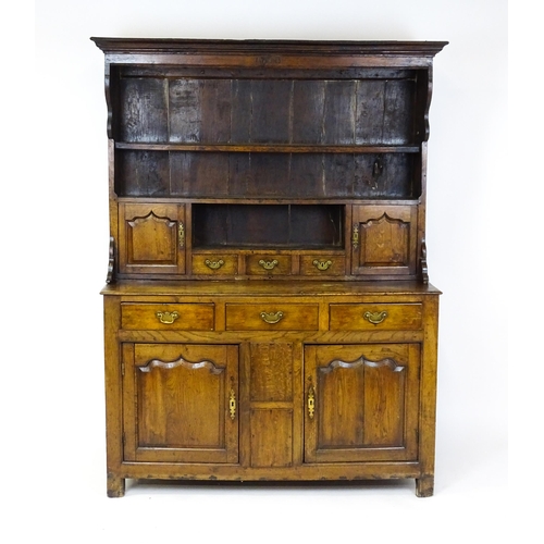 1591 - A mid 18thC oak dresser with a moulded cornice above three graduated shelves flanked by panelled cup... 