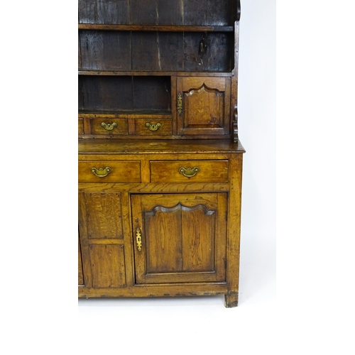 1591 - A mid 18thC oak dresser with a moulded cornice above three graduated shelves flanked by panelled cup... 