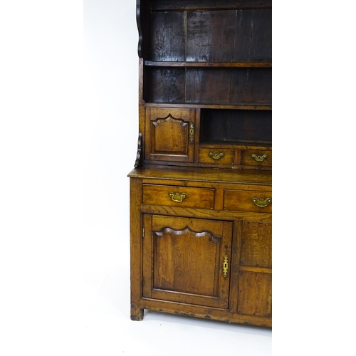 1591 - A mid 18thC oak dresser with a moulded cornice above three graduated shelves flanked by panelled cup... 