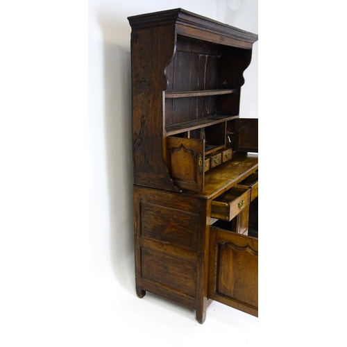 1591 - A mid 18thC oak dresser with a moulded cornice above three graduated shelves flanked by panelled cup... 