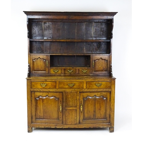 1591 - A mid 18thC oak dresser with a moulded cornice above three graduated shelves flanked by panelled cup... 