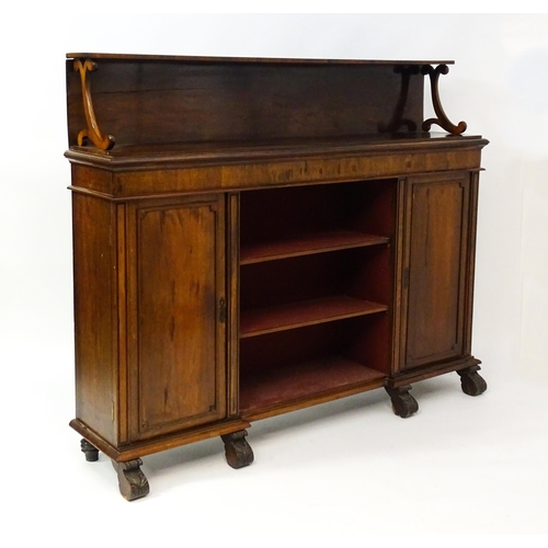 1593 - A 19thC rosewood bookcase with a moulded shelf raised on two scrolled brackets, the base having two ... 