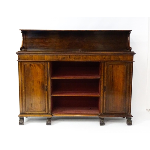 1593 - A 19thC rosewood bookcase with a moulded shelf raised on two scrolled brackets, the base having two ... 