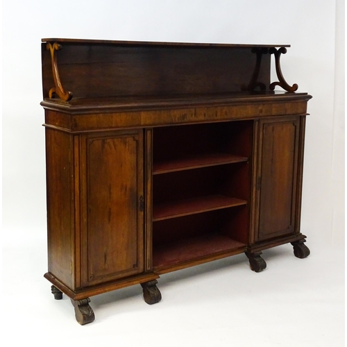 1593 - A 19thC rosewood bookcase with a moulded shelf raised on two scrolled brackets, the base having two ... 