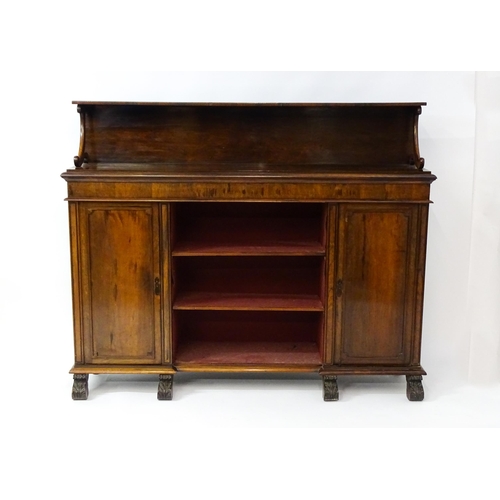 1593 - A 19thC rosewood bookcase with a moulded shelf raised on two scrolled brackets, the base having two ... 