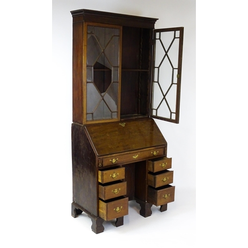 1602 - A Georgian mahogany bureau bookcase, with a moulded top above two astragal glazed doors and a fall f... 