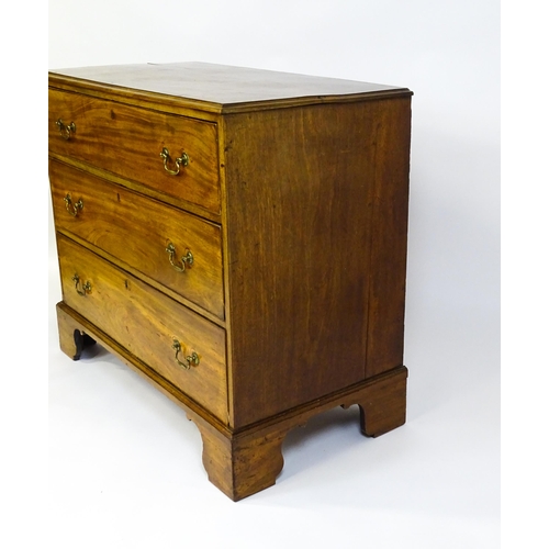 1611 - A late Georgian mahogany chest of drawers with a rectangular moulded top above three long drawers wi... 