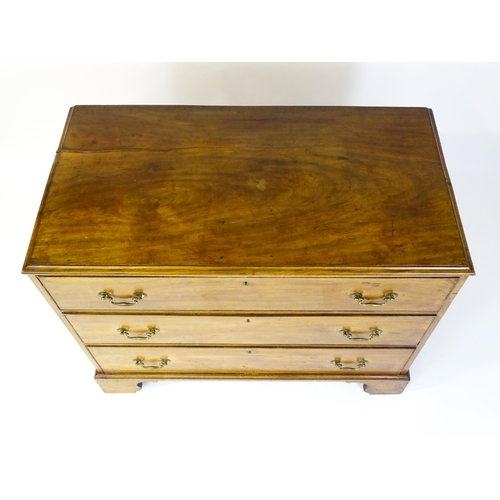 1611 - A late Georgian mahogany chest of drawers with a rectangular moulded top above three long drawers wi... 