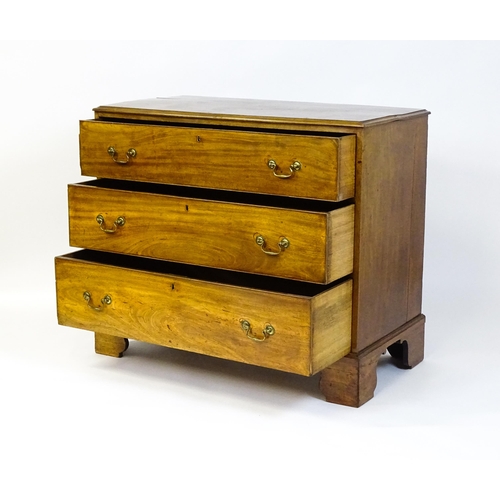 1611 - A late Georgian mahogany chest of drawers with a rectangular moulded top above three long drawers wi... 