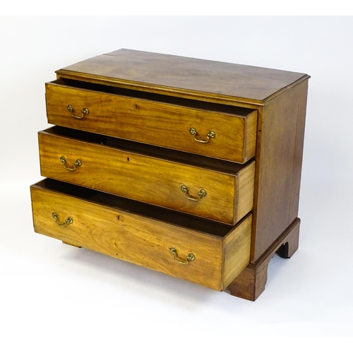 1611 - A late Georgian mahogany chest of drawers with a rectangular moulded top above three long drawers wi... 