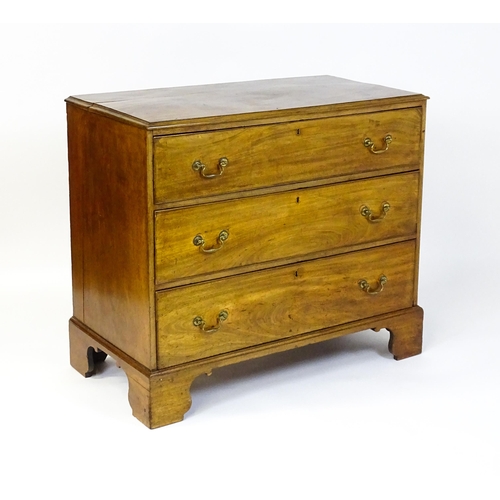 1611 - A late Georgian mahogany chest of drawers with a rectangular moulded top above three long drawers wi... 