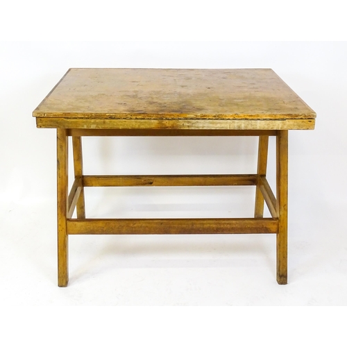 1625 - A mid / late 20thC artists desk with a hinged, adjustable top raised on tapering legs united by a bo... 