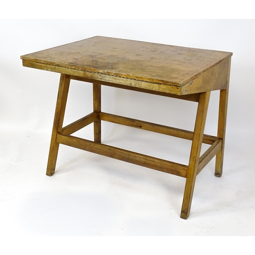 1625 - A mid / late 20thC artists desk with a hinged, adjustable top raised on tapering legs united by a bo... 