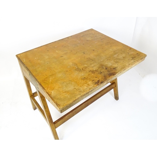 1625 - A mid / late 20thC artists desk with a hinged, adjustable top raised on tapering legs united by a bo... 