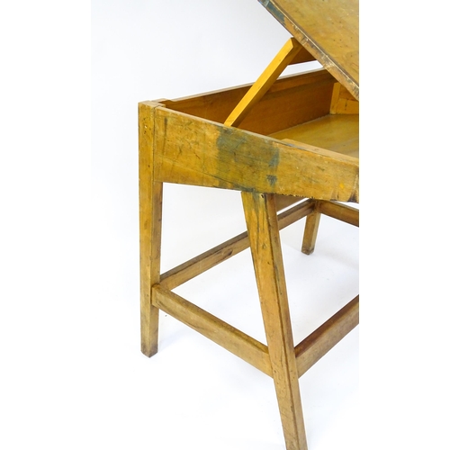 1625 - A mid / late 20thC artists desk with a hinged, adjustable top raised on tapering legs united by a bo... 