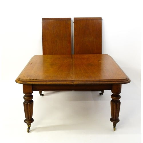 1652 - A 19thC mahogany dining table with a moulded top above turned, reeded and tapering legs terminating ... 