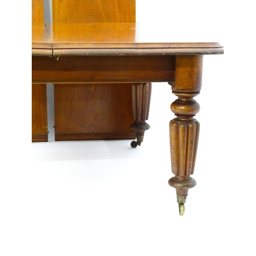 1652 - A 19thC mahogany dining table with a moulded top above turned, reeded and tapering legs terminating ... 