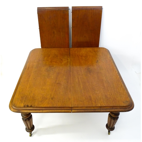 1652 - A 19thC mahogany dining table with a moulded top above turned, reeded and tapering legs terminating ... 