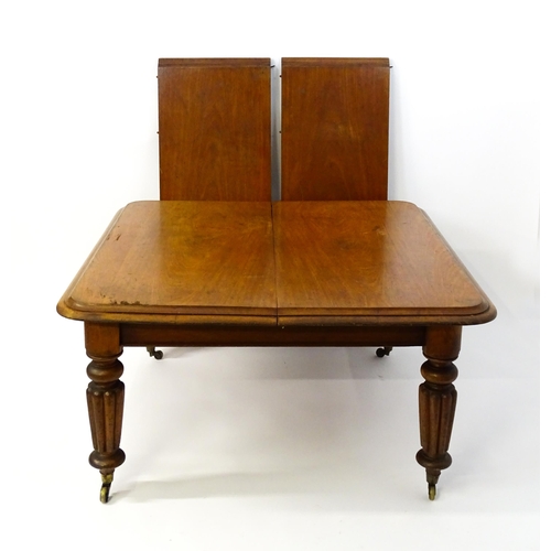 1652 - A 19thC mahogany dining table with a moulded top above turned, reeded and tapering legs terminating ... 