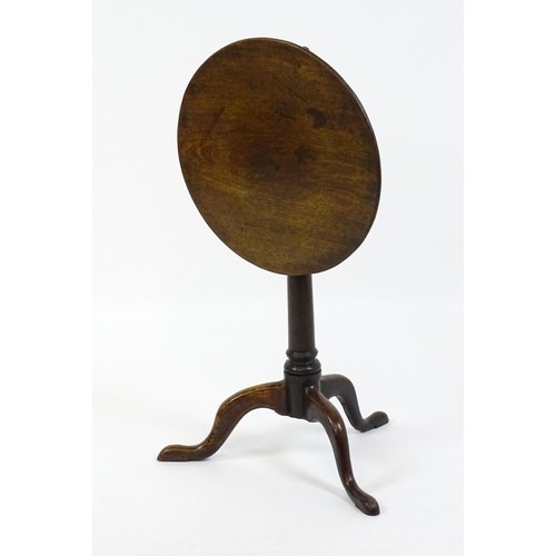 1659 - A late 18thC / early 19thC mahogany tripod table with a circular tilt top above a turned pedestal an... 