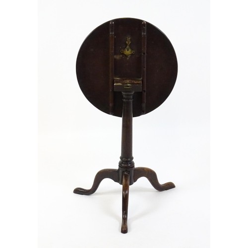 1659 - A late 18thC / early 19thC mahogany tripod table with a circular tilt top above a turned pedestal an... 