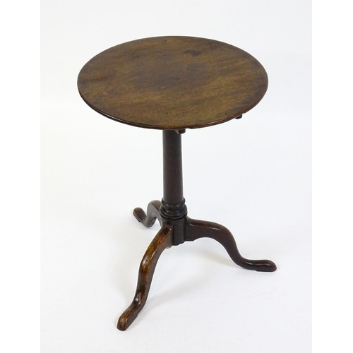 1659 - A late 18thC / early 19thC mahogany tripod table with a circular tilt top above a turned pedestal an... 