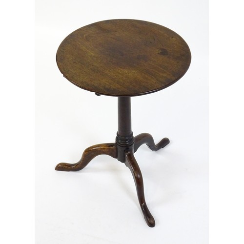 1659 - A late 18thC / early 19thC mahogany tripod table with a circular tilt top above a turned pedestal an... 