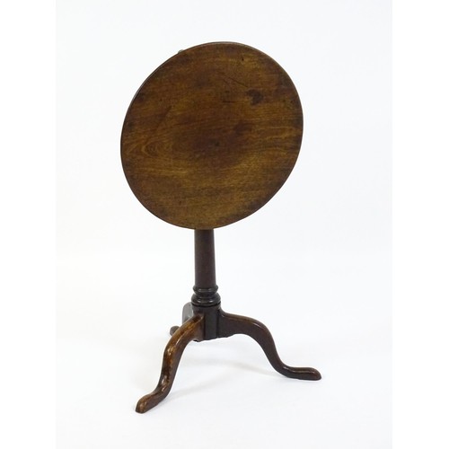 1659 - A late 18thC / early 19thC mahogany tripod table with a circular tilt top above a turned pedestal an... 