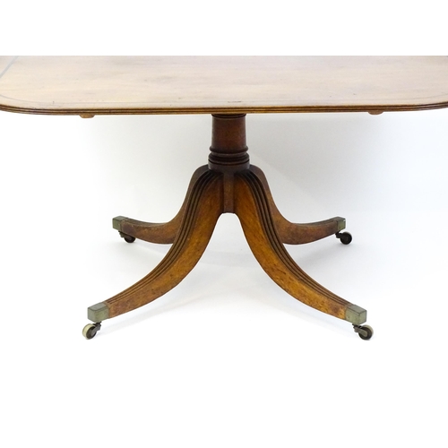 1665 - A late Georgian mahogany tilt top dining table with a ebonised stringing, a turned pedestal and rais... 