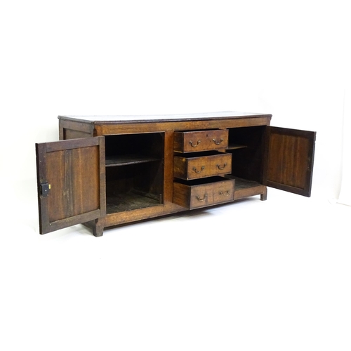 1672 - An 18thC oak dresser with a two plank top above two panelled cupboards and three central drawers wit... 