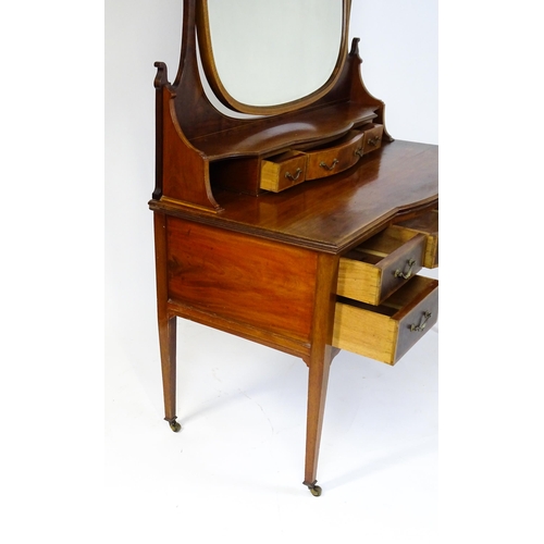 1709 - A late 19thC / early 20thC mahogany Maple & Co dressing table with a decoratively strung mirror abov... 