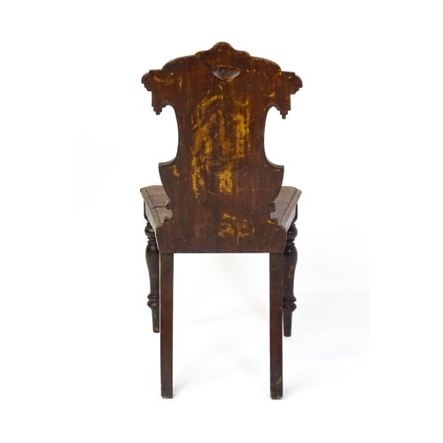 1716 - A Victorian oak shield back hall chair raised on baluster turned front legs and sabre back legs. 17