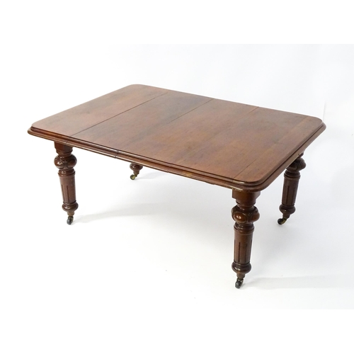 1723 - A 19thC mahogany dining table with a moulded top edge raised on four carved legs raised on four tape... 