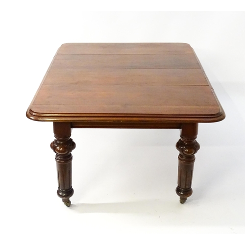 1723 - A 19thC mahogany dining table with a moulded top edge raised on four carved legs raised on four tape... 