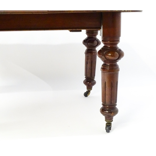 1723 - A 19thC mahogany dining table with a moulded top edge raised on four carved legs raised on four tape... 