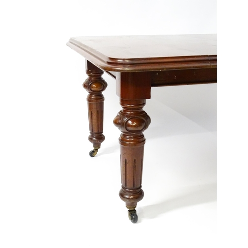 1723 - A 19thC mahogany dining table with a moulded top edge raised on four carved legs raised on four tape... 