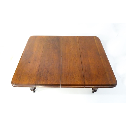 1723 - A 19thC mahogany dining table with a moulded top edge raised on four carved legs raised on four tape... 