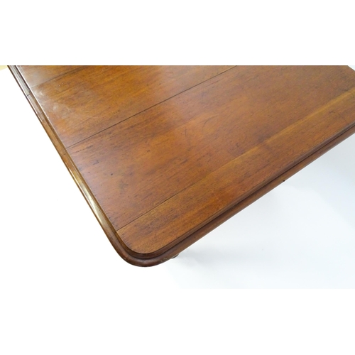 1723 - A 19thC mahogany dining table with a moulded top edge raised on four carved legs raised on four tape... 