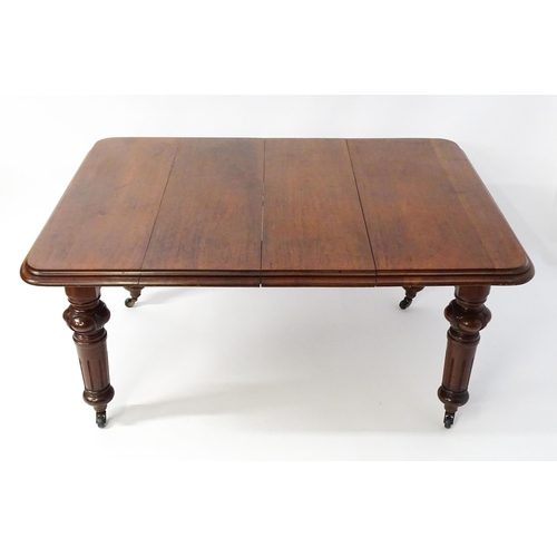 1723 - A 19thC mahogany dining table with a moulded top edge raised on four carved legs raised on four tape... 