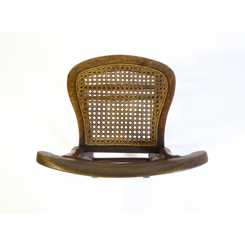 1729 - A Victorian child's chair with a bowed top and mid rail above a caned seat and raised on turned tape... 