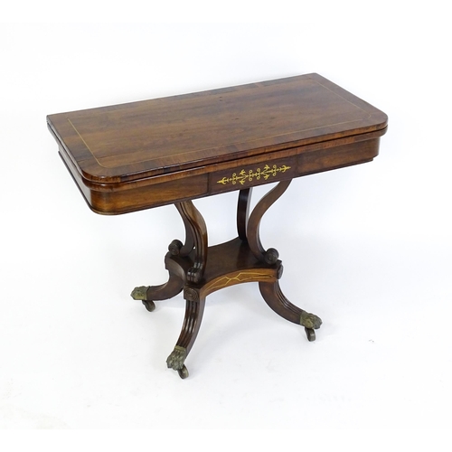 1560 - A Regency rosewood card table with inlaid brass stringing, the revolving top opening to show a baize... 