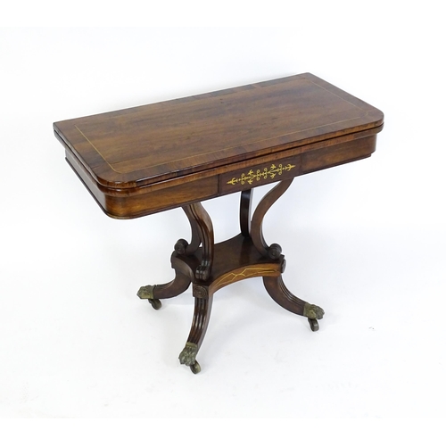 1560 - A Regency rosewood card table with inlaid brass stringing, the revolving top opening to show a baize... 